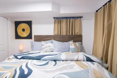 a bed with a blue and white comforter and pillows at BrightOAK Eloire-Private in Newark