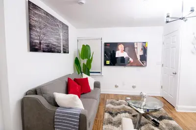 a living room with a gray couch and red pillows at BrightOAK Eloire-Private in Newark