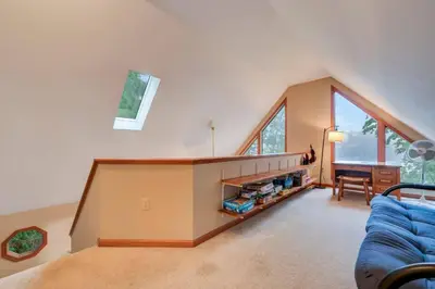 a living room with a blue couch and some windows at beautiful lakefront lodge in Lake Harmony
