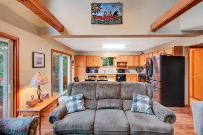 a living room with a couch and a kitchen at beautiful lakefront lodge in Lake Harmony