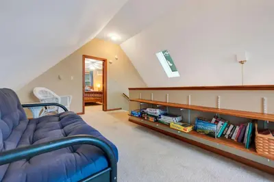 a living room with a couch and a book shelf at beautiful lakefront lodge in Lake Harmony