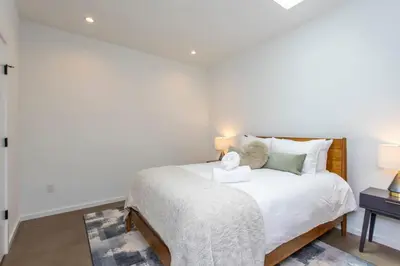 a white bedroom with a bed and a table at Inventors Loft Luxury Upscale Quiet Two Bedroom in Philadelphia