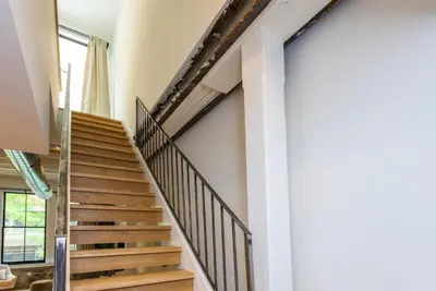 a winding staircase in a house with wooden railings at Inventors Loft Luxury Upscale Quiet Two Bedroom in Philadelphia