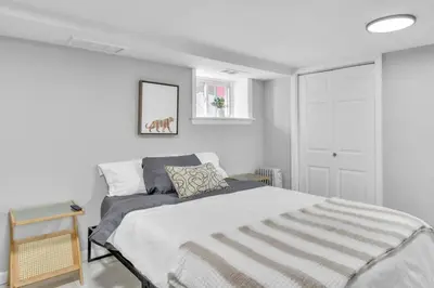 a bedroom with a bed with a striped blanket at Cozy Private Apartment Near NYC Light Rail in Bayonne