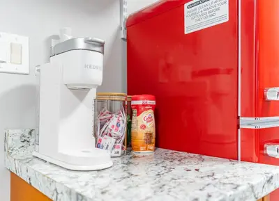 a mixer on a counter next to a red refrigerator at Cozy Private Apartment Near NYC Light Rail in Bayonne