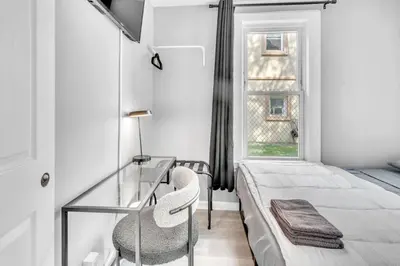 a bedroom with a glass desk and a bed at Cozy Modern Apt Close to NYC NO STEPS or Stairs in South Hackensack