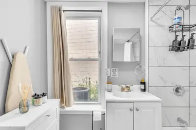 a white bathroom with a sink and a shower at Cozy Modern Apt Close to NYC NO STEPS or Stairs in South Hackensack
