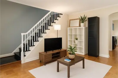 a living room with a tv and a staircase at Cozy Drexel Hill Retreat - Perfect for Families in Drexel Hill