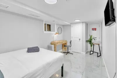 a white bedroom with a bed and a desk at Cozy Private Room in Shared Space NYC Light Rail in Bayonne