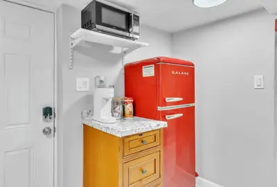 a small kitchen with a red refrigerator and a microwave at Cozy Private Room in Shared Space NYC Light Rail in Bayonne