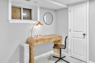 a desk with a lamp and a chair in a room at Cozy Private Room in Shared Space NYC Light Rail in Bayonne