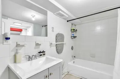 a bathroom with a sink and a tub and a toilet at Cozy Private Room in Shared Space NYC Light Rail in Bayonne