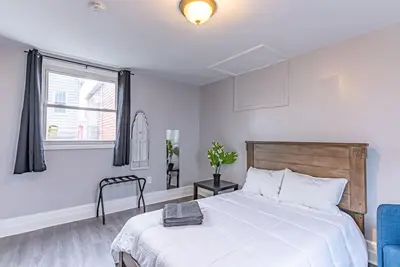 a white bedroom with a bed and a window at 6Br 2bth NYC Penn Station NYC USA Mall EWR in Newark