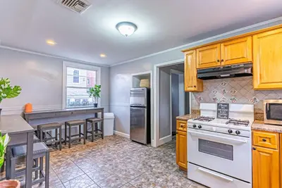 a kitchen with wooden cabinets and a white stove top oven at 6Br 2bth NYC Penn Station NYC USA Mall EWR in Newark
