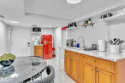 a kitchen with a table and a red refrigerator at Cozy Private Room in Shared Space NYC Light Rail BSMT A in Bayonne