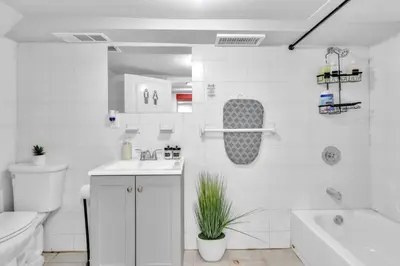 a bathroom with a toilet and a sink and a tub at Cozy Private Room in Shared Space NYC Light Rail BSMT A in Bayonne