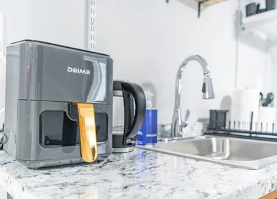 a toaster sitting on a kitchen counter next to a sink at Cozy Private Room in Shared Space NYC Light Rail BSMT A in Bayonne