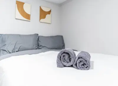 a bed with two towels on top of it at Cozy Private Room in Shared Space NYC Light Rail BSMT A in Bayonne