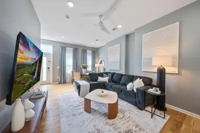 a living room with a couch and a tv at NYC Skyline Views • Near Times Sq • Rooftop Deck in Jersey City
