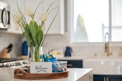 a vase with flowers on a counter in a kitchen at NYC Skyline Views • Near Times Sq • Rooftop Deck in Jersey City