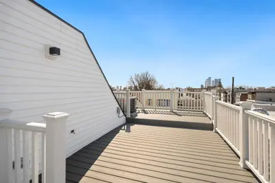 a deck with white railings on a house at NYC Skyline Views • Near Times Sq • Rooftop Deck in Jersey City