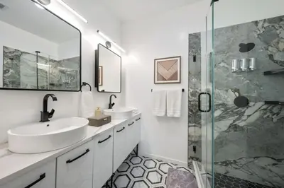a bathroom with two sinks and a shower at NYC Skyline Views • Near Times Sq • Rooftop Deck in Jersey City