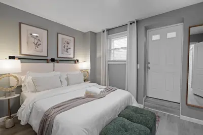 a bedroom with a large white bed and a window at Modern Condo with Private Porch, Mins to NYC in Jersey City