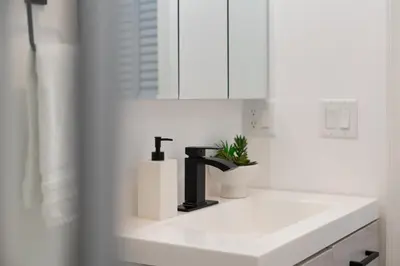 a bathroom sink with a black faucet on it at Modern Condo with Private Porch, Mins to NYC in Jersey City