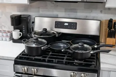 three pots sitting on top of a stove in a kitchen at Modern Condo with Private Porch, Mins to NYC in Jersey City