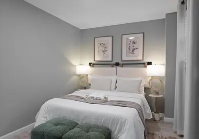a bedroom with a white bed with a green ottoman at Modern Condo with Private Porch, Mins to NYC in Jersey City