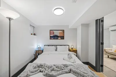 a bedroom with a bed with a blanket on it at luxury 2 bed 2 bath apt with free parking in Jersey City