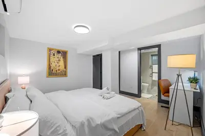 a bedroom with a large white bed and a desk at luxury 2 bed 2 bath apt with free parking in Jersey City