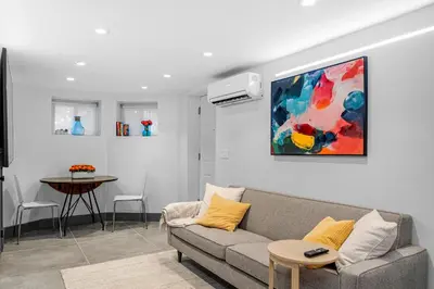 a living room with a couch and a painting on the wall at luxury 2 bed 2 bath apt with free parking in Jersey City
