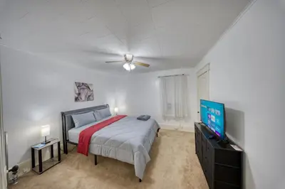 a bedroom with a bed and a flat screen tv at Charming 2-Bedroom, 1-Bath Getaway in Carbondale