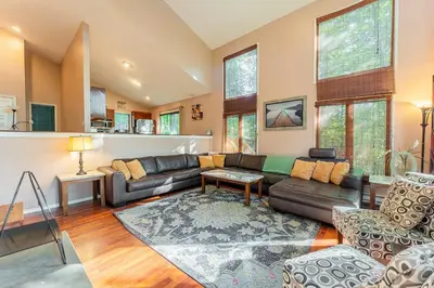 a living room with a couch and a table at Switch to hosting Peaceful Lakefront Stay, HotTub, Fireplace, Kayaks in East Stroudsburg