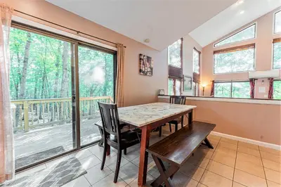 a dining room with a table and chairs and a large window at Switch to hosting Peaceful Lakefront Stay, HotTub, Fireplace, Kayaks in East Stroudsburg