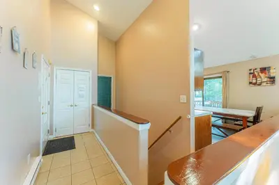 a hallway with a staircase leading to a dining room at Switch to hosting Peaceful Lakefront Stay, HotTub, Fireplace, Kayaks in East Stroudsburg