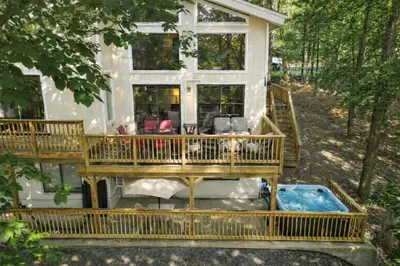 a house with a wrap around deck and a pool at Switch to hosting Peaceful Lakefront Stay, HotTub, Fireplace, Kayaks in East Stroudsburg