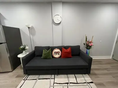 a black couch with four colorful pillows in a room at Chic New Apt in Heart of Philly in Philadelphia