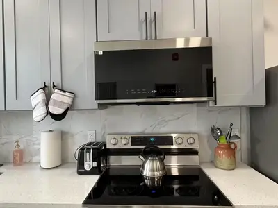 a kitchen with a microwave above a stove at Chic New Apt in Heart of Philly in Philadelphia
