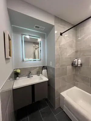 a bathroom with a sink and a tub and a mirror at Chic New Apt in Heart of Philly in Philadelphia