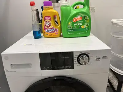 a white microwave with detergents on top of it at Chic New Apt in Heart of Philly in Philadelphia