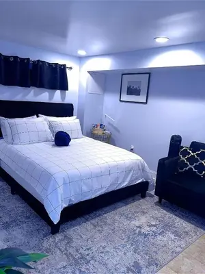 a bedroom with a large white bed and a chair at Philly Stay by TJ in Philadelphia