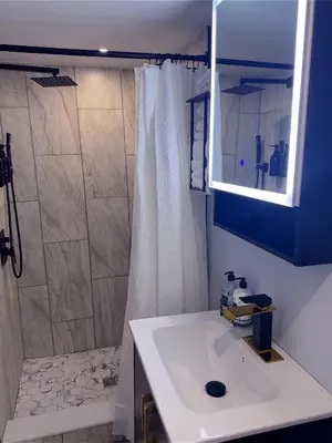 a bathroom with a white sink and a shower at Philly Stay by TJ in Philadelphia
