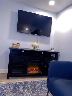 a living room with a fireplace with a tv above it at Philly Stay by TJ in Philadelphia