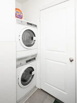 a white laundry room with a washer and dryer at Spacious 3BR Retreat Near Times Square in New York