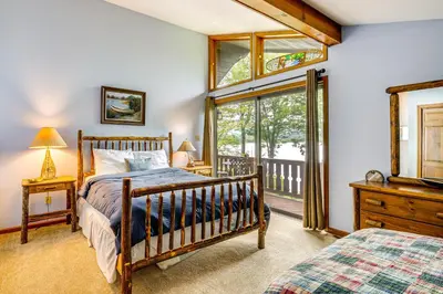 a bedroom with a bed and a window at Beech Mt Lakefront Gem! Hot Tub, Kayaks, Billiards