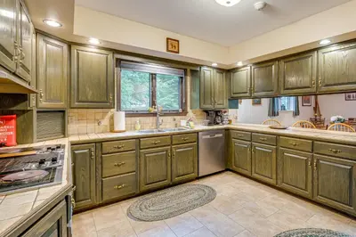 a large kitchen with wooden cabinets and appliances at Beech Mt Lakefront Gem! Hot Tub, Kayaks, Billiards