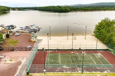 an aerial view of a tennis court next to a lake at Beech Mt Lakefront Gem! Hot Tub, Kayaks, Billiards