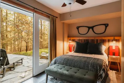 a bedroom with a bed with glasses on the wall at Tuthill Treehouse - Secluded Mountain Cabin with Roof Deck & Fire Pit in Pond Eddy